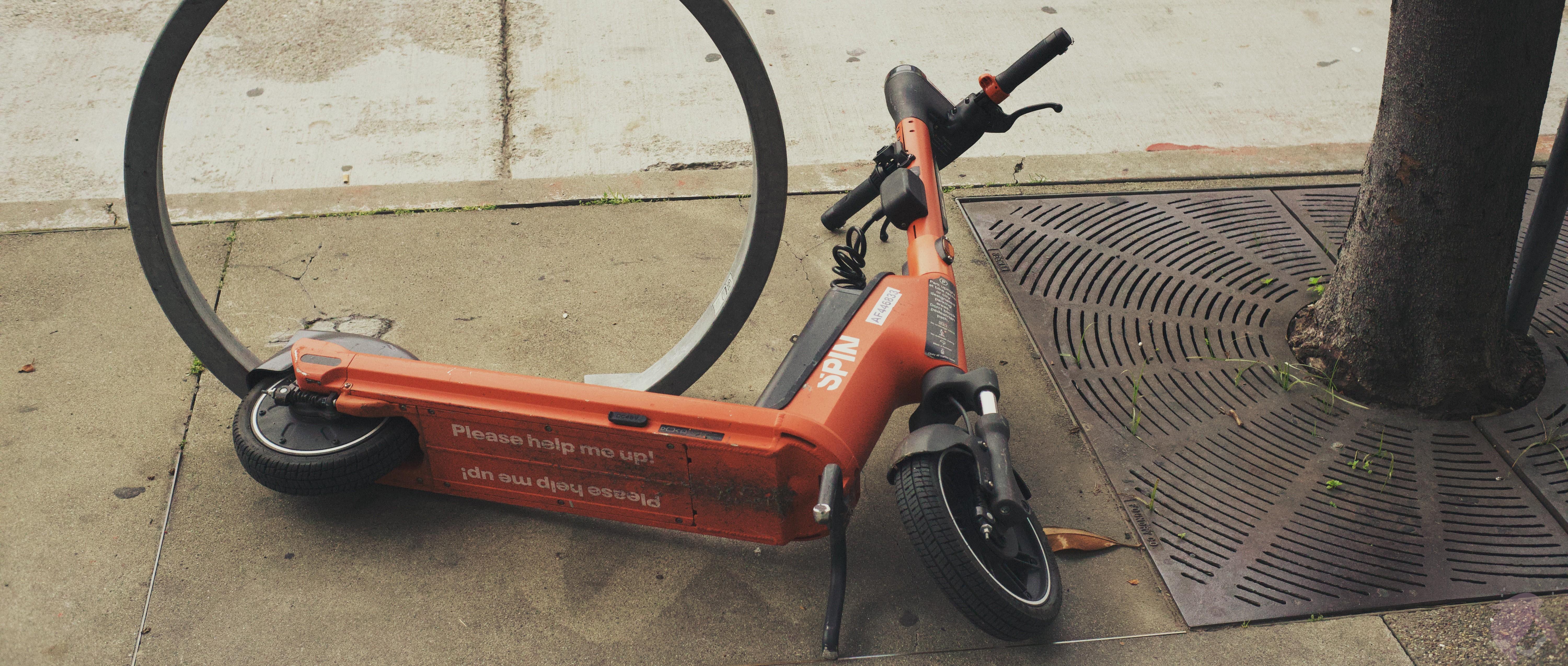 An image of A red electric scooter on its side with the label